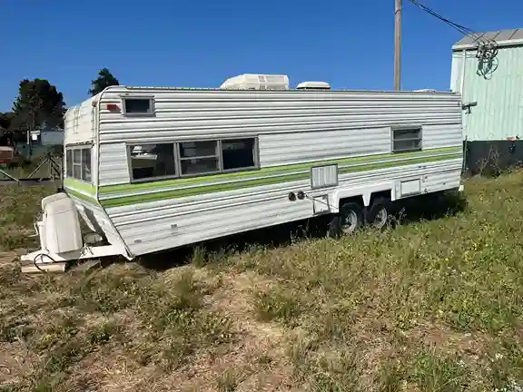 Old RV trailer parked in the backyard ready to be hauled away